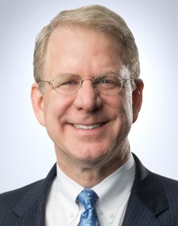 A man in a suit smiling